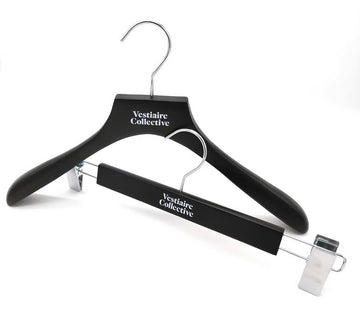 Cintre de veste et cintre à pinces en bois noir personnalisés avec le logo Vestiaire Collective en blanc